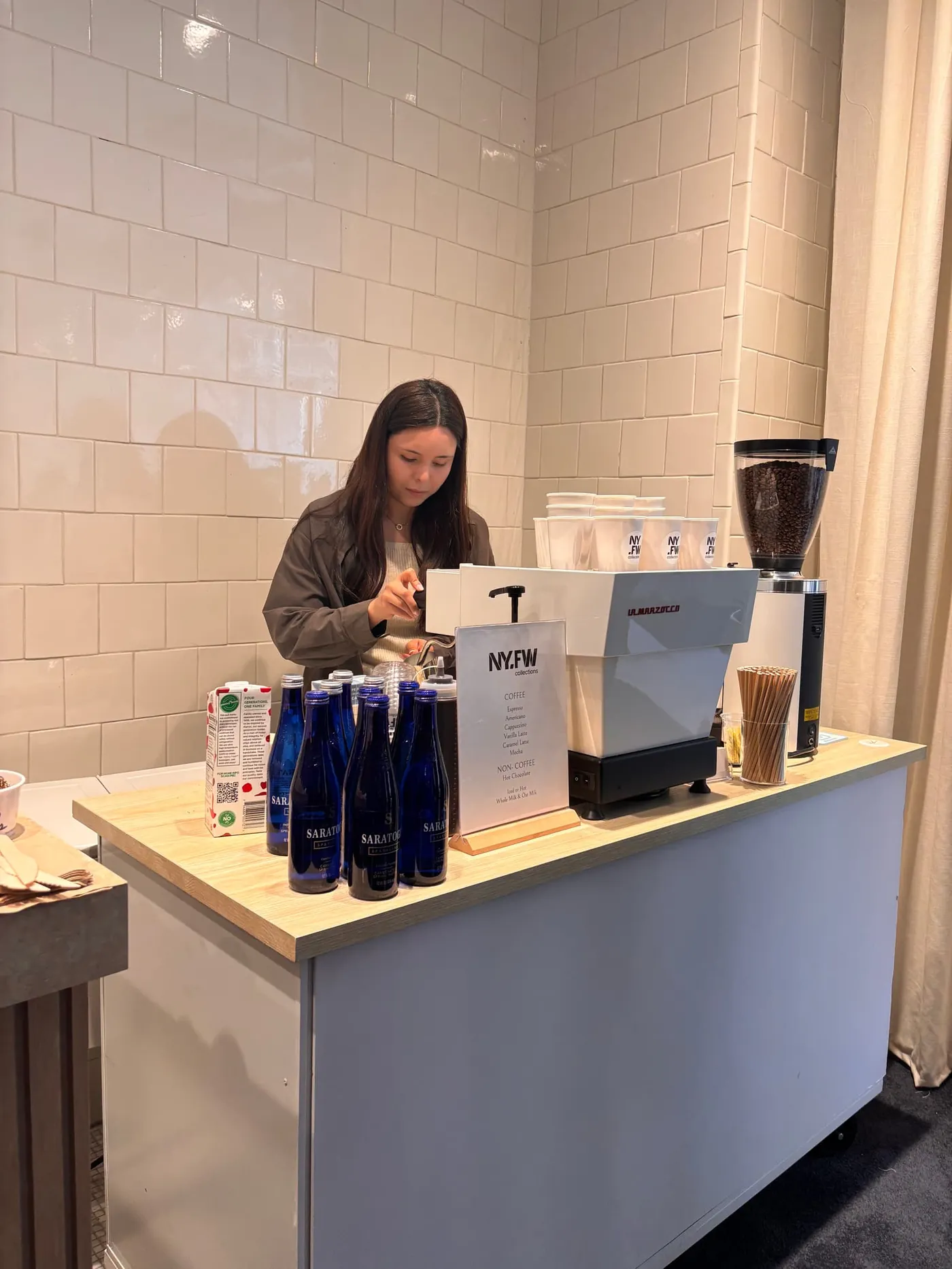 Barista pulling espresso on a La Marzocco machine at a coffee cart in a NY Fashion Week showroom