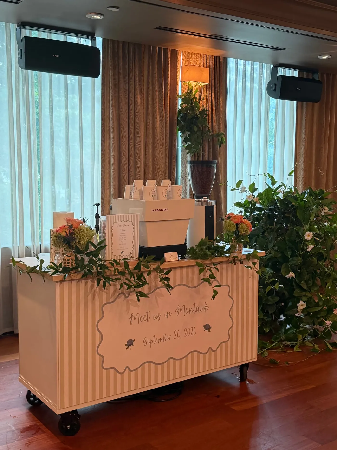 Peach striped coffee cart dressed in greenery with a custom Meet us in Montauk sign