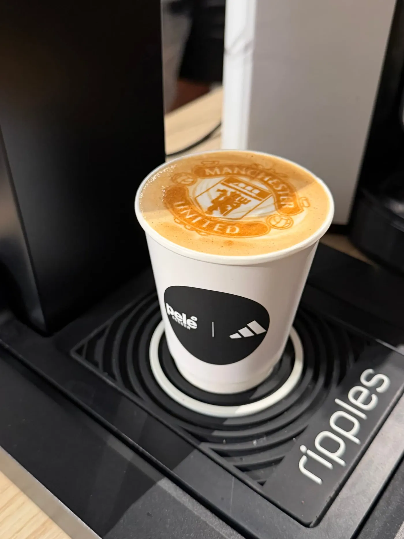 Latte with a club crest printed on the foam in a black Pelé x adidas cup